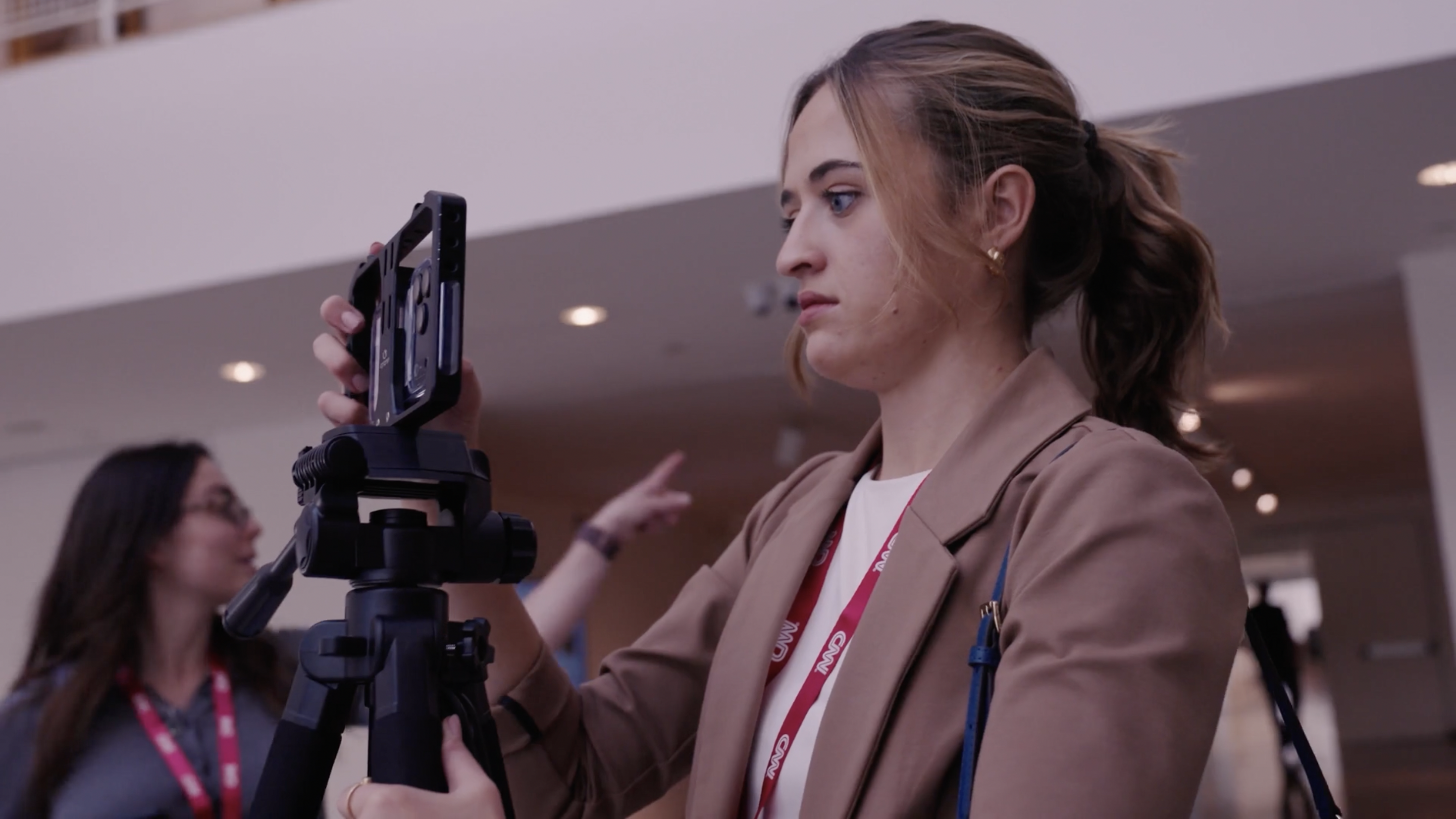 Woman using a phone and tripod to shoot a video